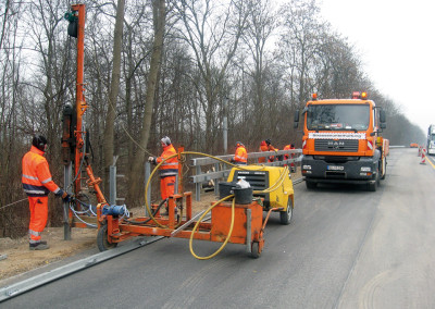 Montage von Stahlschutzsystem an einer Landstraße