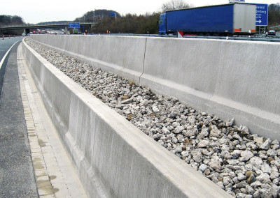 Zwei Betonschutzwände mit Zwischenraumabdeckung durch Grobschotter